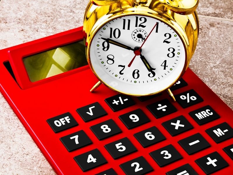 a clock on top of a calculator to depict time conversion