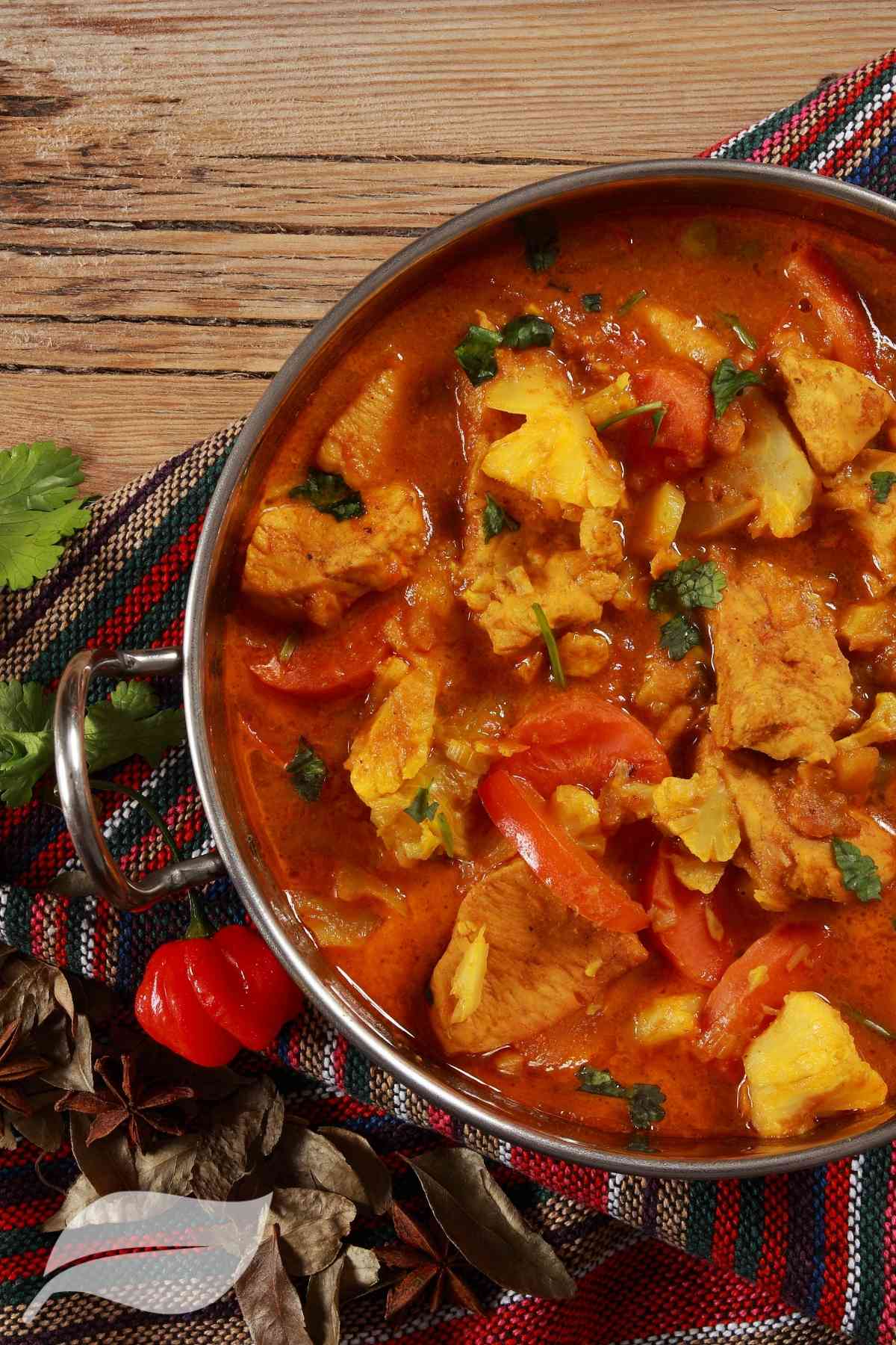 Easy chicken curry in a balti style dish with coriander leaves on the side
