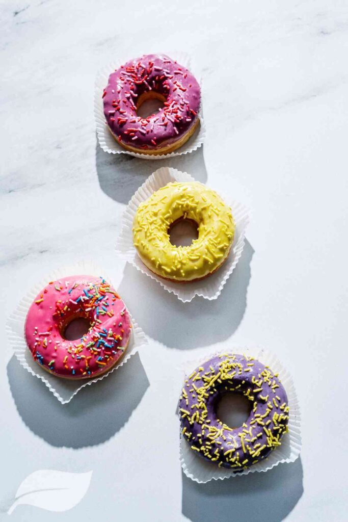 Four Air Fried Donuts with pink, yellow brown and purple frosting