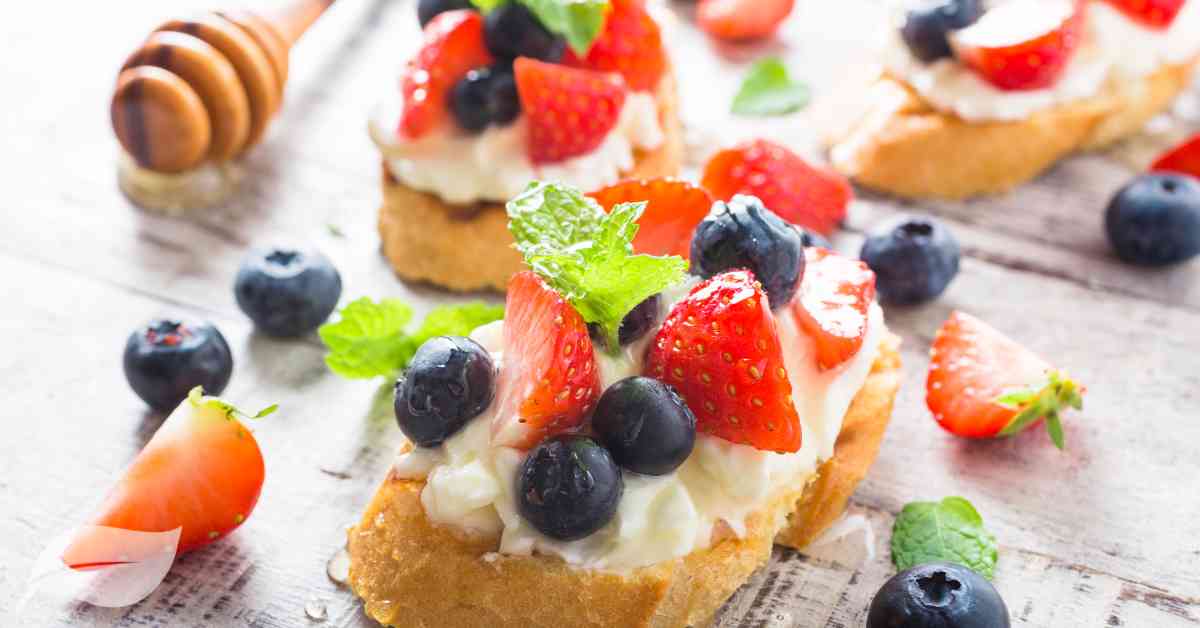 4th July Appetizer themed bruschetta with blueberries, cream cheese and strawberries