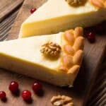 two pieces of cheesecake on a wooden board