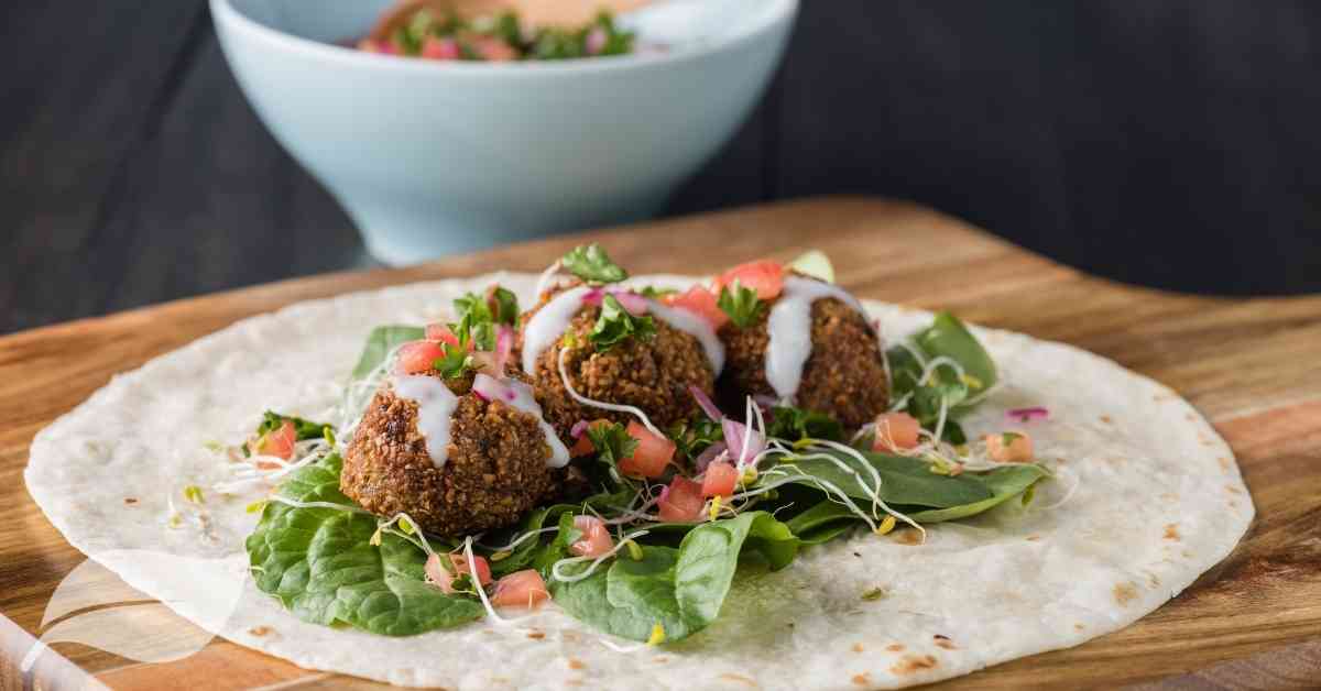 vegan appetizer of breaded mushrooms on a bed of lettuce and a wrap
