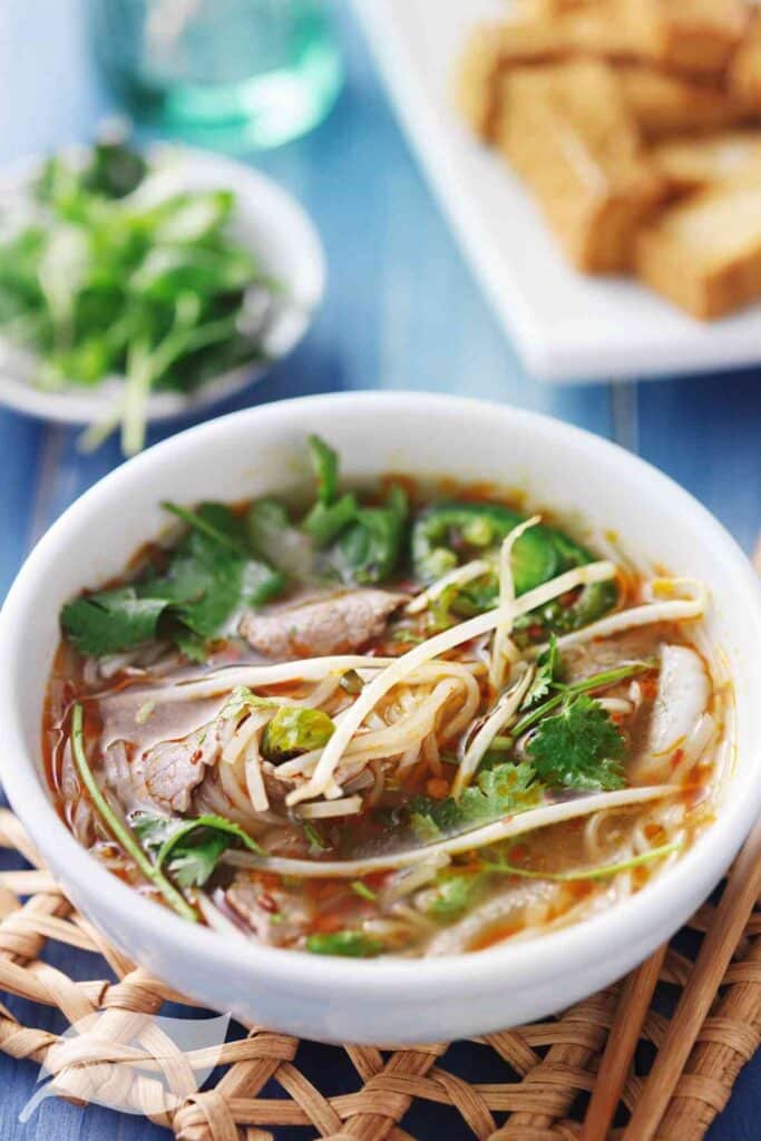 a white bowl with vietnamese noodle soup