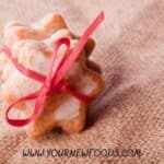 two cinnamon star shaped cookies held together with a red ribbon