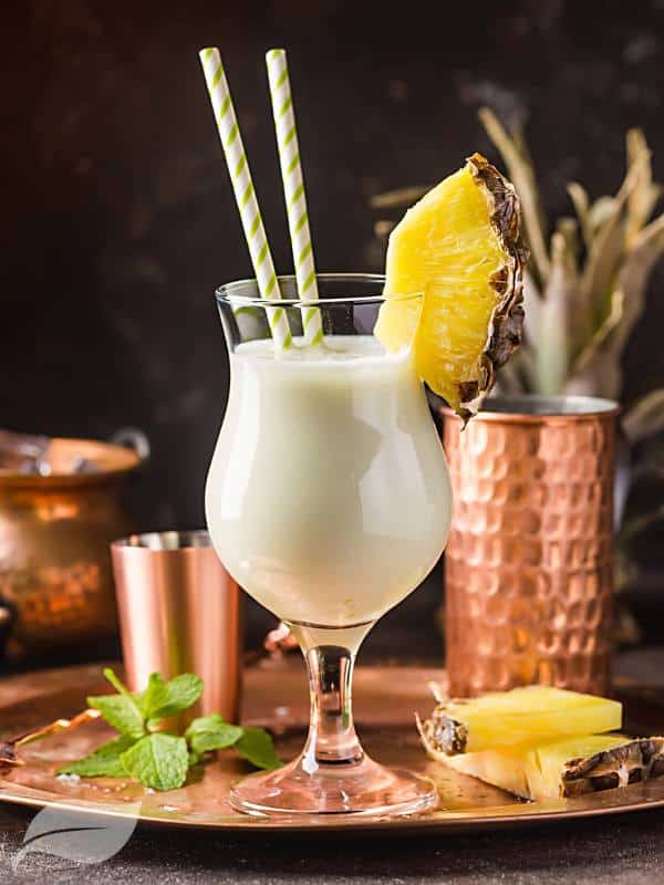 pina colada with pineapple next to the glass