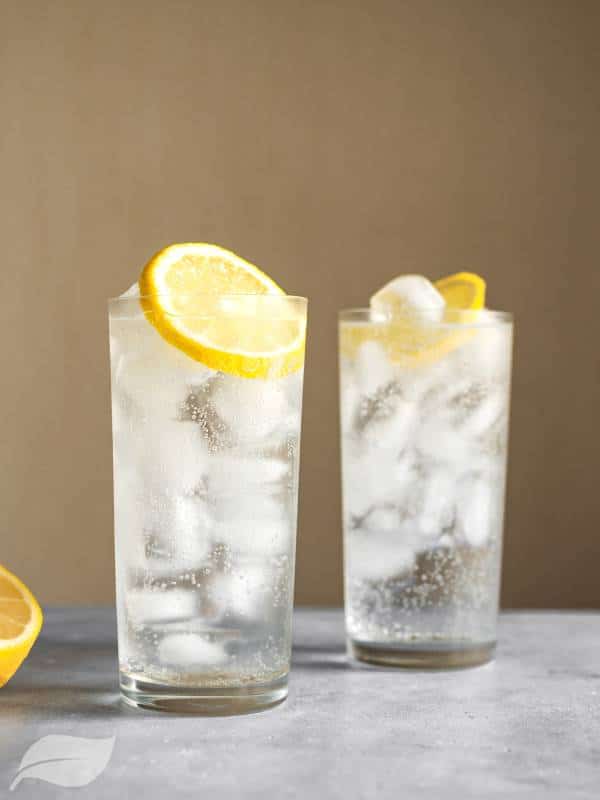 two tom collins cocktails with orange